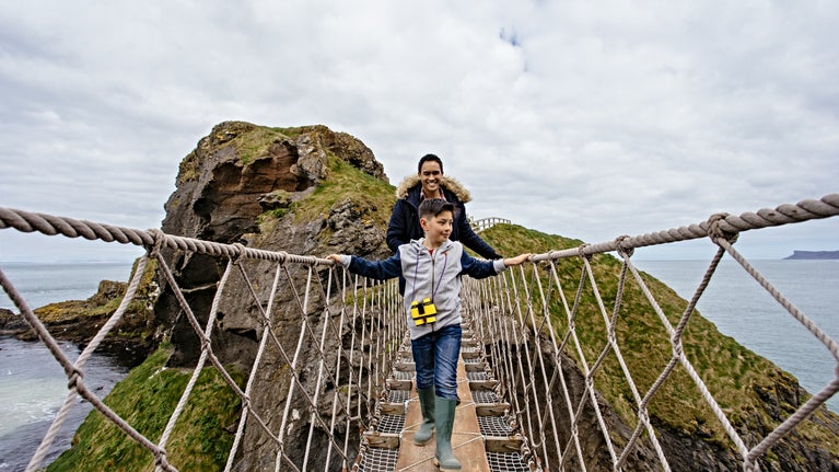 A man and a young boy crossing Carrick-a-Rede Rope Bridge